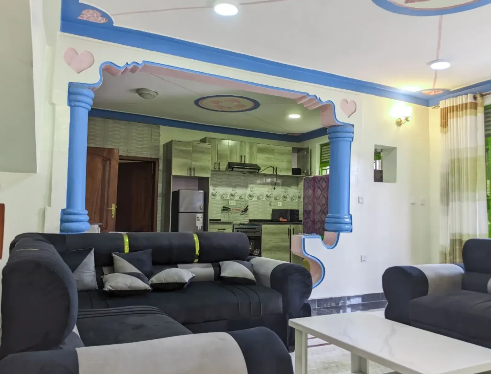 The living room and the kitchen beyond the arch