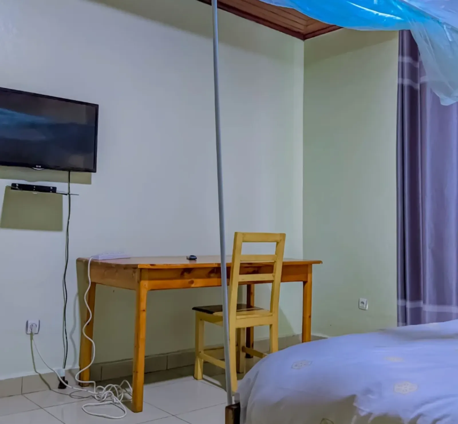 A bedroom, with a desk and a television